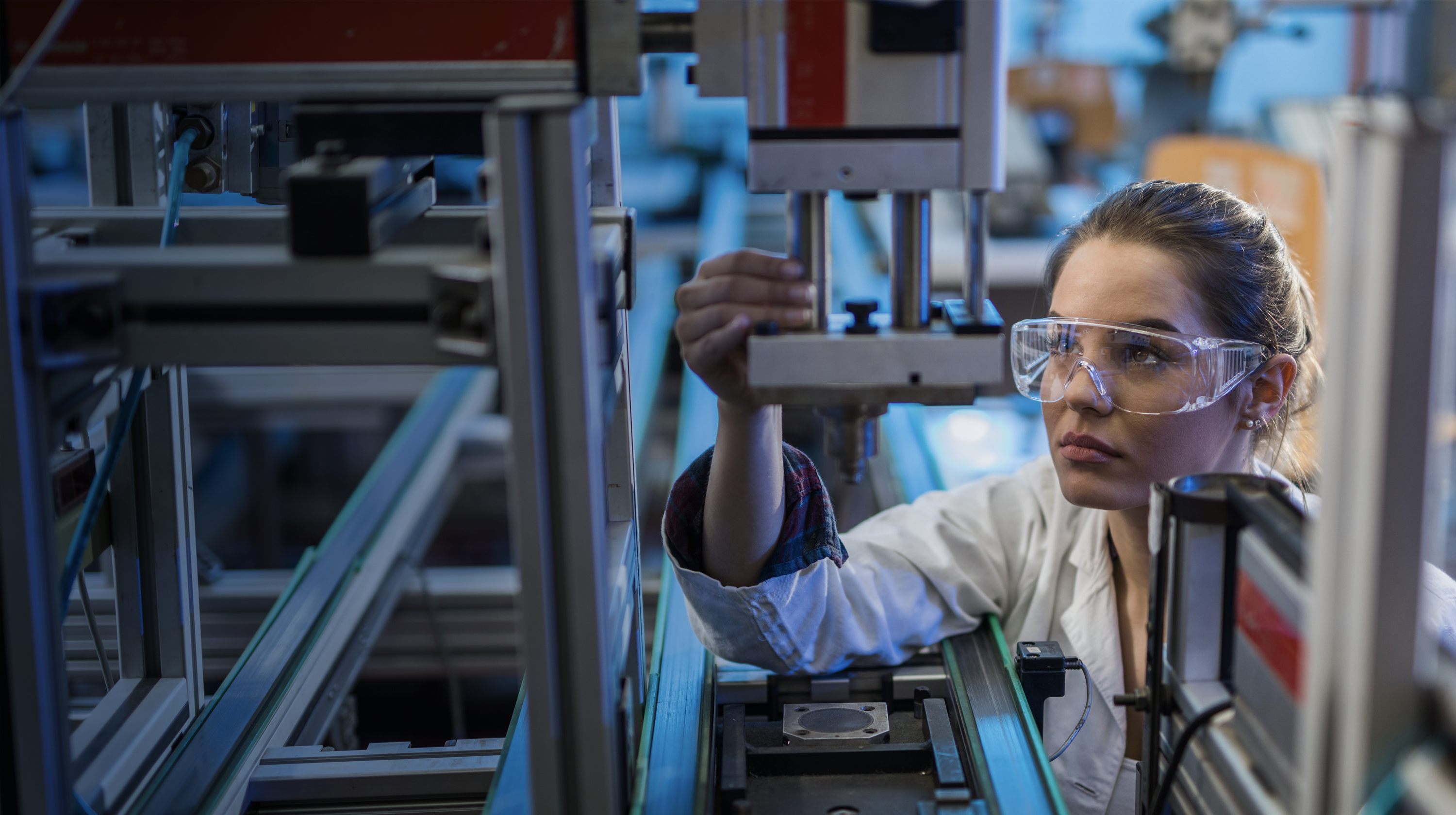 Female engineer examining machine part on a production line