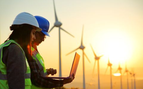 Man and woman wearing hard hats on solar wind farm site