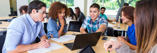 Students in classroom around a laptop